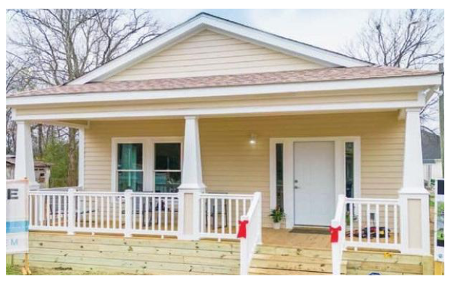 Front view of house with red bows tied on railing to front door.